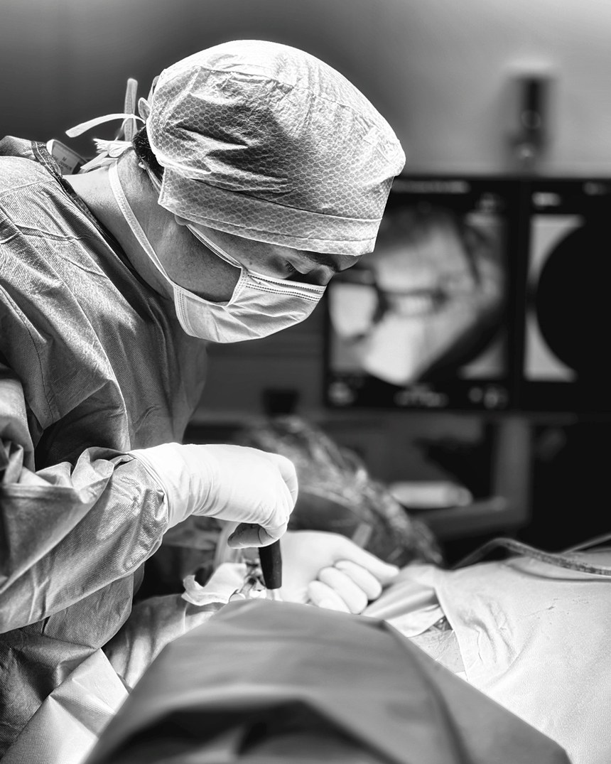 Le chirurgien pendant l'intervention, le contrôle radiologique en arrière-plan